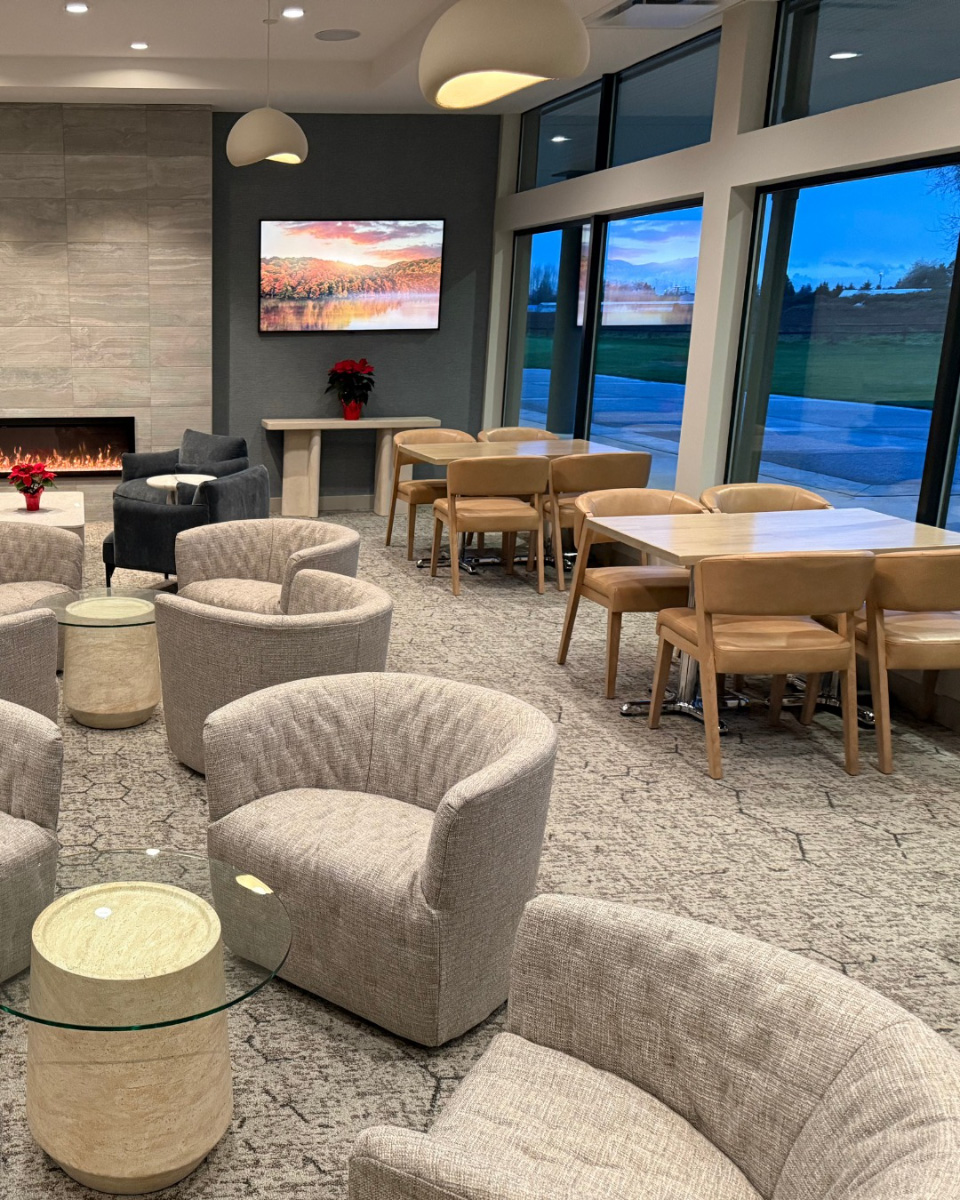 The-photo-features-a-modern-lounge-area-with-a-fireplace-and-large-windows-Member_Lounge-Pitt-Meadow